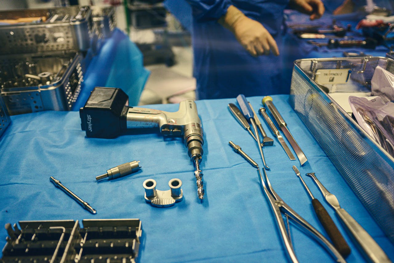 A selection of surgical tools and equipment on a sterile table in an operating room.