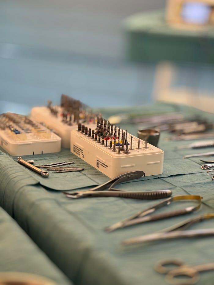 Surgical tools and dental instruments organized on a sterile table in an operating room.